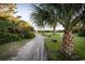Scenic pathway lined with palm trees and lush greenery, leading to the beach at 4806 S Ocean Blvd., Surfside Beach, SC 29575