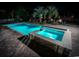 An inviting pool and hot tub area illuminated at night, complete with lounge chairs and palm trees at 4806 S Ocean Blvd., Surfside Beach, SC 29575