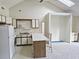 Cozy kitchen with a breakfast bar, white appliances, and carpeted floors, under a high ceiling at 500 Fairway Village Dr. # 9-K, Myrtle Beach, SC 29588