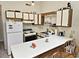 Cozy kitchen featuring a breakfast bar, wood trimmed cabinets and white appliances at 500 Fairway Village Dr. # 9-K, Myrtle Beach, SC 29588