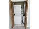 A laundry closet featuring a stacked washer and dryer unit beside the water heater with louvered doors at 500 Fairway Village Dr. # 9-K, Myrtle Beach, SC 29588