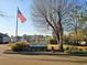 View of 'Fairway Village' signage with the American flag waving nearby on a sunny day at 500 Fairway Village Dr. # 9-K, Myrtle Beach, SC 29588