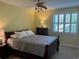Comfortable bedroom featuring a ceiling fan, window with shutters, and bedside table with lamp at 5001 Little River Rd. # W101, Myrtle Beach, SC 29577