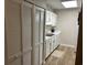 This kitchen has white cabinetry, a stainless steel sink, and a long closet with folding doors at 5001 Little River Rd. # W101, Myrtle Beach, SC 29577