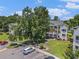 Low-rise condos include parking and landscaping among mature trees and lawns at 537 White River Dr. # 17C, Myrtle Beach, SC 29579