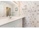 Bathroom with single sink vanity, large mirror, and seashell themed wallpaper at 537 White River Dr. # 17C, Myrtle Beach, SC 29579