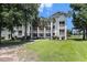 Beautiful condo building featuring classic architecture, balconies, and a lush green lawn with mature trees at 537 White River Dr. # 17C, Myrtle Beach, SC 29579