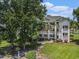 Exterior of a charming condo building with multiple balconies and well-maintained lawn at 537 White River Dr. # 17C, Myrtle Beach, SC 29579