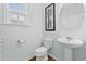 Half bath showcasing pedestal sink, toilet, framed art and a window offering plenty of natural light at 540 Chanted Dr., Murrells Inlet, SC 29576
