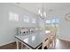 Bright dining room featuring hardwood floors, modern chandelier, large glass table, and plenty of seating at 540 Chanted Dr., Murrells Inlet, SC 29576