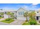 Charming two-story beach home featuring palm trees, a front porch, and a two-car garage at 540 Chanted Dr., Murrells Inlet, SC 29576