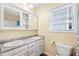 Bright bathroom featuring a double sink vanity, ample storage, toilet, and a window at 6001- P16A S Kings Highway, Myrtle Beach, SC 29575
