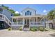 Inviting two-story home featuring a spacious front porch, stone foundation, and manicured landscaping at 6001- P16A S Kings Highway, Myrtle Beach, SC 29575
