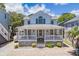 Welcoming two-story house with a covered porch, stone foundation, and sunny curb appeal at 6001- P16A S Kings Highway, Myrtle Beach, SC 29575