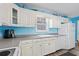 White cabinets and appliances in this eat-in kitchen with light blue walls and trim at 6001- P16A S Kings Highway, Myrtle Beach, SC 29575