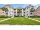 Inviting multi-story condo building featuring manicured lawn, palm trees, and private balconies at 627 Waterway Village Blvd. # 8E, Myrtle Beach, SC 29579