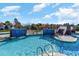 Meandering resort-style pool with tiled water features, lounge area, and immaculate landscaping at 7179 Shooting Star Way, Myrtle Beach, SC 29579