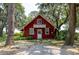 Charming red cottage with a white balcony and a backdrop of mature trees at 951 Herriott Farms Dr., Georgetown, SC 29440