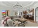 Open-concept living and kitchen area with a large sofa, decorative lighting, and a view of the outdoor pool at 9737 Catalonia Ct., Myrtle Beach, SC 29579