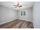 Bright bedroom showcasing wood floors, a ceiling fan, and a window for natural light at 100 St. Andrews Ln., Myrtle Beach, SC 29588