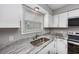 The kitchen features white cabinets, stainless steel appliances, and light marble-look countertops at 100 St. Andrews Ln., Myrtle Beach, SC 29588