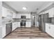 Updated kitchen with stainless steel appliances, white cabinetry, and wood-look flooring at 100 St. Andrews Ln., Myrtle Beach, SC 29588
