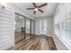 Bright sunroom featuring wood-look floors, ceiling fan, sliding glass doors, and ample natural light at 100 St. Andrews Ln., Myrtle Beach, SC 29588