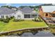 Aerial view showcasing a home with a screened patio, landscaped yard, and a pond with a wooden dock at 1024 Pochard Dr., Conway, SC 29526