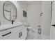 Elegant bathroom featuring white vanity, a sleek black faucet, an oval mirror, and marble-patterned flooring at 1024 Pochard Dr., Conway, SC 29526