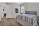 Cozy bedroom featuring a queen bed with striped bedding, complemented by a framed jersey and a window with blinds at 1024 Pochard Dr., Conway, SC 29526