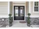 Elegant double front door with glass panels, flanked by topiaries, creating a welcoming entrance at 1024 Pochard Dr., Conway, SC 29526