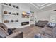 Open-concept living room with a fireplace, decorative shelves, and comfortable gray reclining sofas at 1024 Pochard Dr., Conway, SC 29526