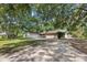 Well maintained house with a large front yard and driveway surrounded by big trees, some of which cast shadows at 103 Wofford Ln., Conway, SC 29526