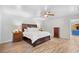 Spacious main bedroom with a wooden bed frame, hardwood floors, and bright lamps at 103 Wofford Ln., Conway, SC 29526