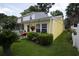 The exterior of this yellow house is enhanced by well-maintained landscaping, a grill, and charming hanging flower baskets at 12 Century St. # 12, Myrtle Beach, SC 29577