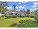 The exterior of this home offers an expansive green backyard with mature landscaping and patio furniture at 1208 Trisail Ln, North Myrtle Beach, SC 29582
