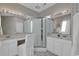 This primary bathroom features a tiled shower with a glass surround, dual sinks, and wallpaper at 1208 Trisail Ln, North Myrtle Beach, SC 29582