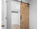 Stylish bathroom with a modern barn door and subway tiled shower at 1331 Bermuda Ct., Surfside Beach, SC 29575