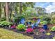 Backyard garden featuring colorful flowers, mulch beds, and comfortable outdoor seating at 139 Olde Canal Loop, Pawleys Island, SC 29585