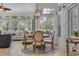 Cozy dining area with a round table, upholstered chairs, and ample natural light from surrounding windows at 139 Olde Canal Loop, Pawleys Island, SC 29585