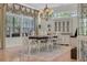 Bright dining room showcasing a chandelier, cabinet, table with white chairs, and large windows at 139 Olde Canal Loop, Pawleys Island, SC 29585