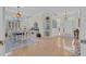 Elegant dining room featuring a classic chandelier, dining table with white chairs, and ample natural light at 139 Olde Canal Loop, Pawleys Island, SC 29585