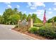 Community entrance sign with lush landscaping and an American flag against a backdrop of mature trees at 139 Olde Canal Loop, Pawleys Island, SC 29585