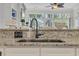 Close up of a granite countertop, stainless steel sink, modern faucet, and white cabinets at 139 Olde Canal Loop, Pawleys Island, SC 29585