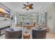 Bright living room featuring a fireplace, ceiling fan, comfortable seating, and views of a golf course at 139 Olde Canal Loop, Pawleys Island, SC 29585