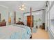 Spacious bedroom featuring a four-poster bed, natural light, and a cozy workspace with a desk and chair at 139 Olde Canal Loop, Pawleys Island, SC 29585