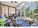Comfortable sunroom with brick wall, large windows, ceiling fan, wicker furniture, and a decorative blue rug at 139 Olde Canal Loop, Pawleys Island, SC 29585
