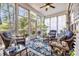 Bright sunroom with large windows, ceiling fan, wicker furniture, and beautiful blue rug at 139 Olde Canal Loop, Pawleys Island, SC 29585