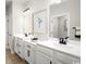 Bright white bathroom with dual sinks, framed mirrors and modern black hardware at 1408 Whistling Straits Way, Sunset Beach, NC 28468