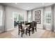 Elegant dining area with a modern table, seating for six, and sliding glass doors to the outdoor living area at 1408 Whistling Straits Way, Sunset Beach, NC 28468